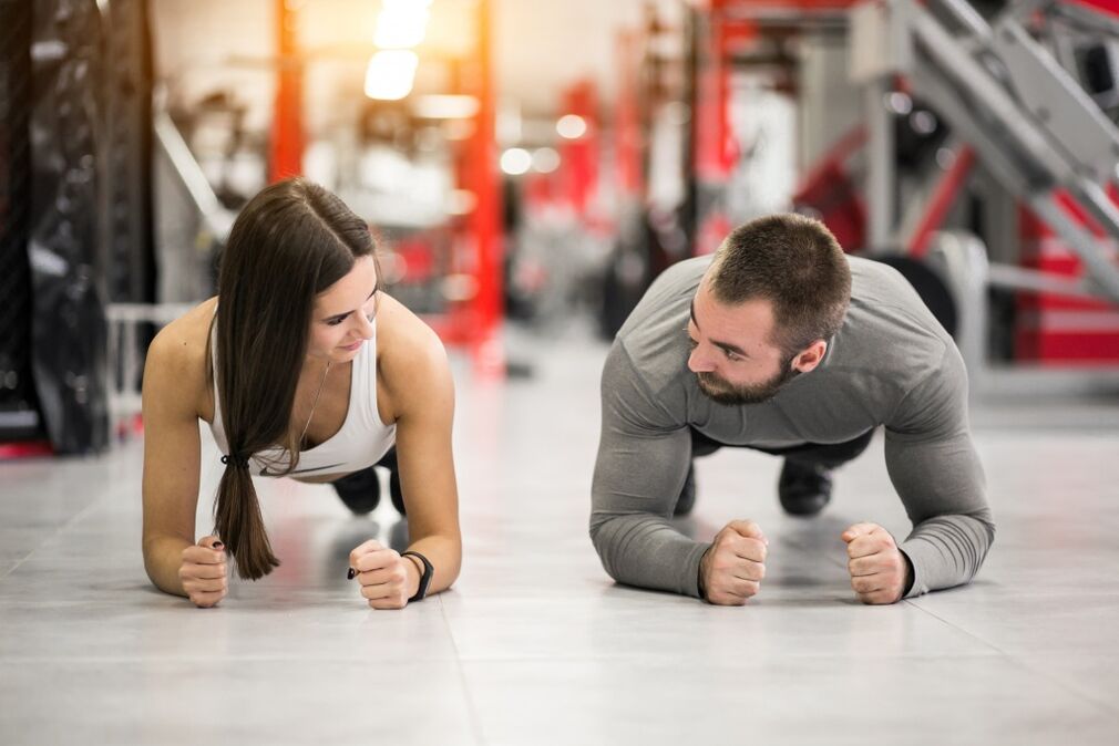 Muž a žena vykonávajú cvičenie Plank, určené pre všetky svalové skupiny
